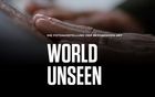 Das Motto der Ausstellung World Unseen. Dabei sieht man eine Hand, die eine Fotografie abtastet